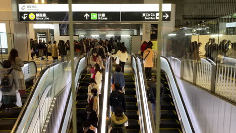 Tracking-shot-of-people-riding-escalators-through-Shibuya-Station-in-Japan