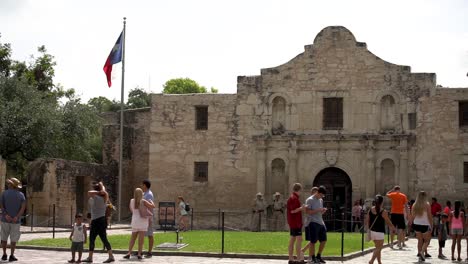 Visitors-stroll-by-the-famous-and-historic-Alamo-on-a-summer-day-in-San-Antonio,-Texas-as-captured-in-slow-motion