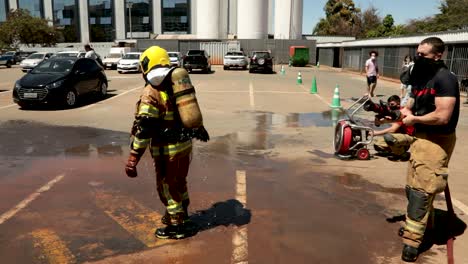 Feuerwehrleute-Dekontaminieren,-Indem-Sie-Mit-Wasser-Besprüht-Werden,-Nachdem-Sie-Das-Covid-19-Krankenhaus-In-Santa-Luzia-Betreten-Haben