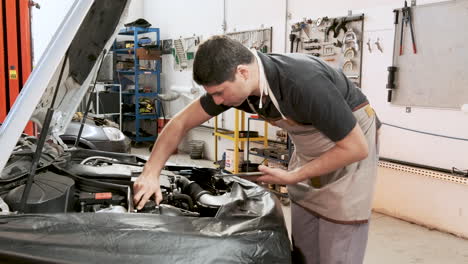 A-professional-mechanic-inspects-a-car-engine-for-faults-or-defects-in-a-professional-garage