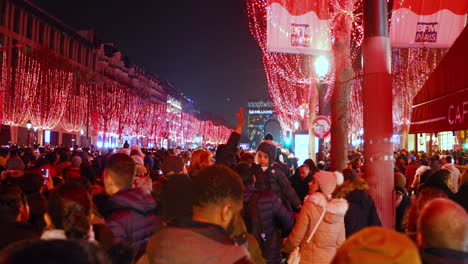 Neujahrsfeier-In-Den-Pariser-Straßen-Champs-Élysées,-Wenige-Augenblicke-Bevor-Die-Ampel-Aufgeht,-Wird-Die-Von-Rotlichtern-Bedeckte-Straße-Mit-Massenhaft-Wartenden-Menschen-In-4K-Aufgenommen