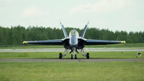 Blue-Angel-F-A-18-Hornet-starting-to-move-on-a-runway,-rolling-and-turning