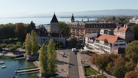Aerial-of-bus-on-street-and-tilting-up-to-church-in-Lausanne,-Switzerland