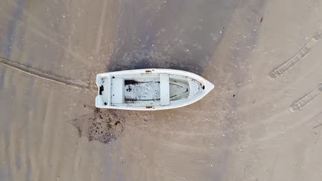 Aerial-view-of-Baltic-sea-coastline-at-Bernati-beach-in-Latvia,-flying-upwards-over-white-sand-beach-and-fisherman-boat,-wide-angle-establishing-drone-shot