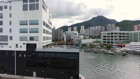 Large-Mercedes-Benz-sign-spinning-on-top-of-Hong-Kong-Mercedes-Benz-main-showroom-in-Chai-Wan-area,-Aerial-view