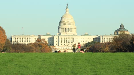 Familia-En-Césped-Verde-Frente-Al-Edificio-Del-Capitolio-Con-La-Biblioteca-Del-Congreso-En-Washington,-Estados-Unidos