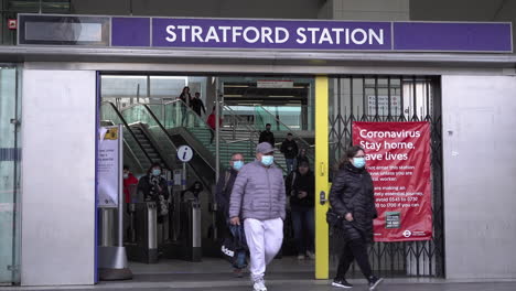 Menschen-Mit-Gesichtsmasken-Verlassen-Den-Bahnhof-Stratford,-Nachdem-Die-Britische-Regierung-Die-Beschränkungen-Für-Die-Sperrung-Von-Coronaviren-Gelockert-Hat.-Dies-Ermutigt-Zur-Rückkehr-An-Den-Arbeitsplatz,-Fordert-Die-Menschen-Jedoch-Auf,-öffentliche-Verkehrsmittel-Zu-Meiden