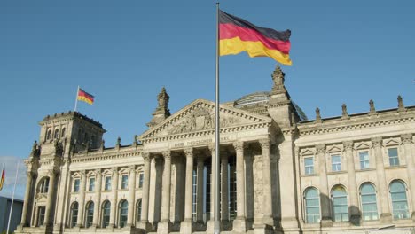 Bandera-De-La-Unidad-Alemana-Ondeando-Junto-Al-Edificio-Del-Reichstag,-La-Sede-Del-Bundestag