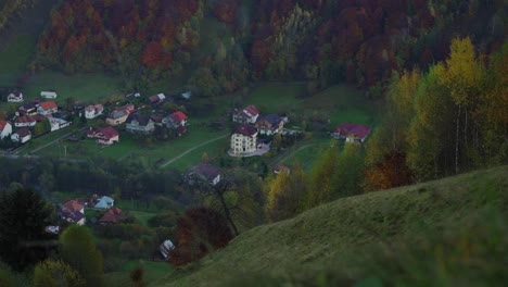 Ruhiges-Dorf-Bei-Herbstlicher-Waldlandschaft-Mit-Hügeln-Unter-Sonnigem-Himmel-In-Piatra-Craiului,-Kreis-Brasov,-Rumänien,-Tilt-Up-Aufnahme