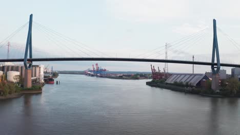 Drone-flight-over-the-port-of-Hamburg-passing-under-the-cable-stayed-Köhlbrand-Bridge-spanning-the-Elbe-River-at-dusk