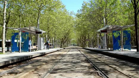 Trolley-Tram-stop-Quinconces-with-a-few-people-waiting-during-the-COVID-19-pandemic,-Handheld-stable-shot