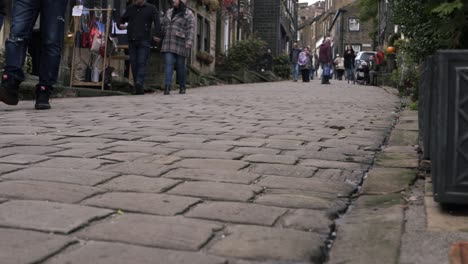 Shoppers-browsing-in-cobbled-street-in-Yorkshire-village-Haworth-low-panning-shot