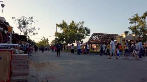 People-gathering-on-a-street-where-mixing-concrete-construction-is-happening,-Pan-left-low-shot