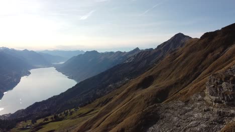 Vista-De-Drones-A-Montañas-Verdes-Con-Un-Hermoso-Lago-Suizo
