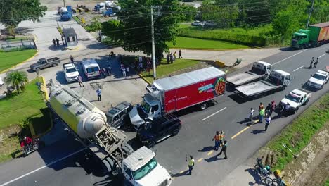 Aerial-view-of-a-traffic-accident,-passenger-car-crushed-underneath-a-truck,-a-wrecked-lorry-being-towed,-in-Puerto-Rico,-USA---tracking,-drone-shot
