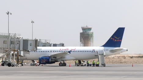 Passenger-Aircraft-Parked-at-the-Gate-Airport-Control-Tower-Background