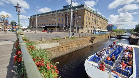 Pan-of-trams,-people-and-sightseeing-boat-in-summertime-Gothenburg