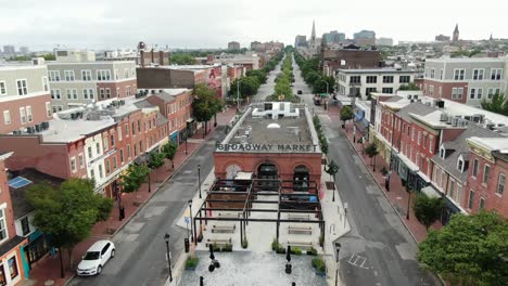 Aerial-reveal-of-Broadway-Market-at-Fells-Point,-no-people-during-COVID-quarantine,-coronavirus-pandemic,-empty-retail-stores-and-restaurants