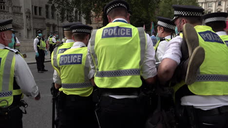 Polizisten-Der-Londoner-Metropolregion-Heben-Verhaftete-Demonstranten-Der-Rebellion-Gegen-Den-Klimawandel-Auf-Und-Tragen-Sie-Fort,-Die-Die-Straße-Vor-Dem-Parlament-In-Westminster-Blockiert-Haben