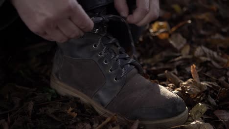 Hiker-tying-laces-on-walking-boot-medium-shot