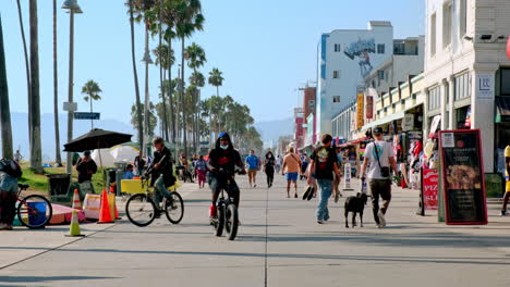 Daytime-in-Venice,-California,-People-Casually-Strolling-Down-Boardwalk-on-Summer-Day