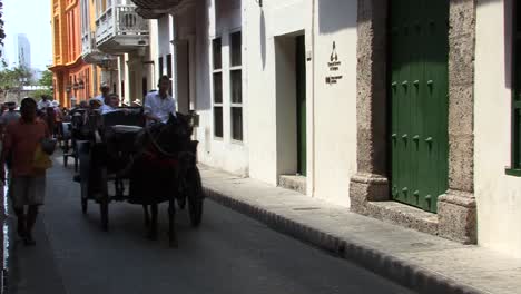 Turistas-Haciendo-Un-Recorrido-Por-El-Casco-Antiguo-De-Cartagena-En-Carruajes-Tirados-Por-Caballos