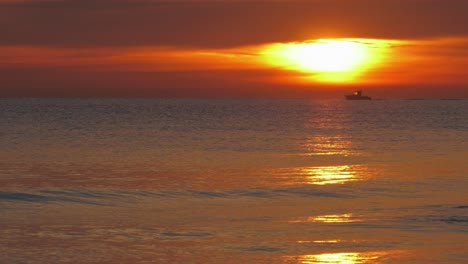 Small-boat-on-calm-ocean-at-sunrise,-mediterranean,-spain,-slow-motion
