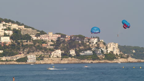 Parasailers-Being-Towed-By-Speedboats-Over-The-Calm-Blue-Sea-In-Nice,-France