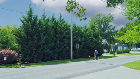 An-Amish-Man-Traveling-on-a-Scooter-on-a-Country-Road-on-a-Summer-Day