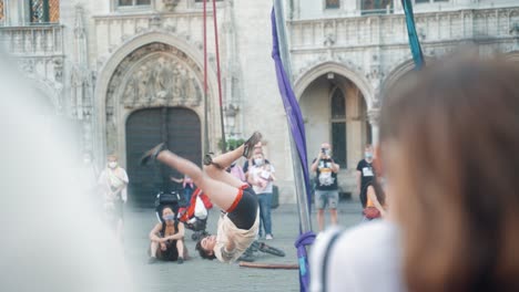 Mujer-Dando-Un-Espectáculo-Callejero-Acrobático-En-La-Gran-Plaza-De-Bruselas-En-El-Verano-Durante-El-Covid-Frente-A-La-Multitud