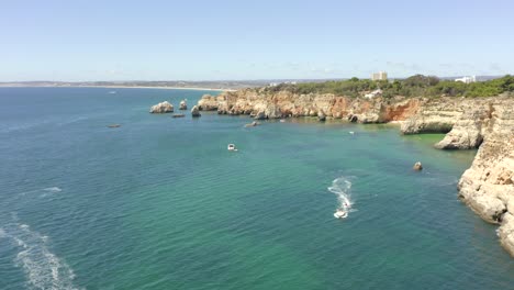 Ein-Episches-Weißes-Motorboot-Rast-An-Einem-Wunderschönen-Tag-Durch-Exotische-Tropische-Gewässer-In-Portimao,-Portugal