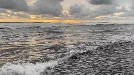 Rolling-Waves-On-Sandy-Seashore-Over-Sky-With-Cloudscape-During-Sunset-In-Indonesia