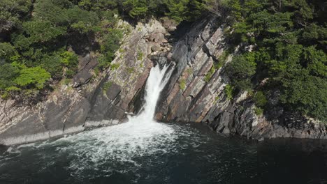 Torohki-Falls,-Tilt-Up-Aerial-of-Waterfall-on-Yakushima-Island,-Southern-Japan