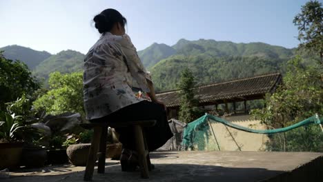 Chinese-woman-thoughtfully-looking-at-the-mountains