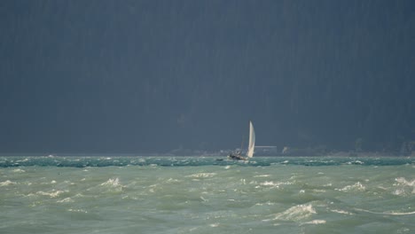 Lonely-Sailboat-at-Rough-Sea-Near-Alaskan-Coastline,-Slow-Motion-Wide-View