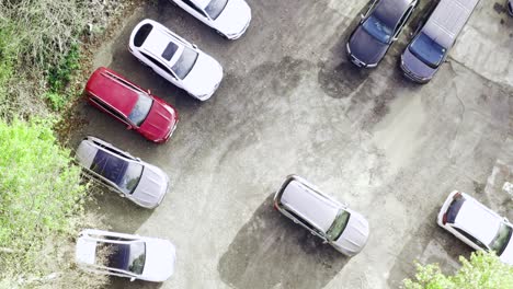 Bird's-eye-view-of-car-dealership-parking-lot-in-a-sunny-morning---Aerial-descending-Rocket-shot