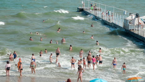 Gente-Nadando-En-Grandes-Olas-Cerca-Del-Muelle-En-El-Mar-Negro