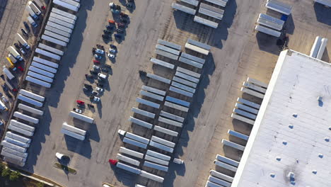 carrier-company-huge-truck-containers-fleet-in-parking-warehouse,-orbital-aerial