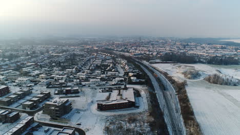 AERIAL:-A-city-and-its-residential-area's-on-a-snowy,-winter-day