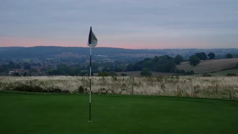 4K-Aufnahme-Eines-Golfplatzgrüns-Und-Einer-Flagge-Bei-Sonnenaufgang