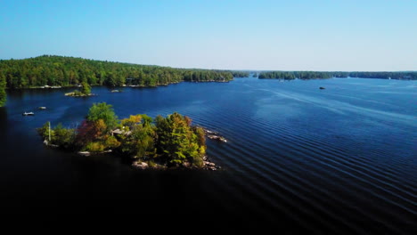 Aerial-footage-over-a-calm,-blue-lake-and-islands-on-a-beautiful,-sunny-summer-day