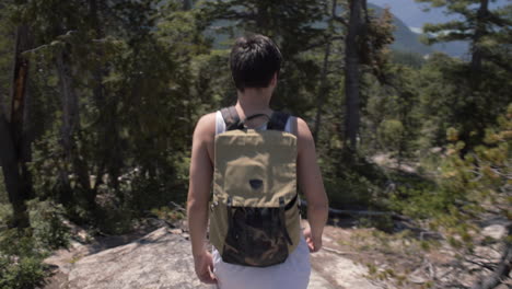 Man-with-backpack-walking-down-the-hill-in-Canadian-wilderness