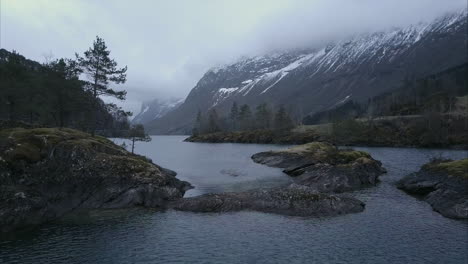 Aufschlussreiche-Luftaufnahme-Der-Norwegischen-Wildnis,-Kleine-Felsige-Inseln-Im-Fjord,-Bedeckt-Von-Moos-Und-Bäumen,-Bewölkt