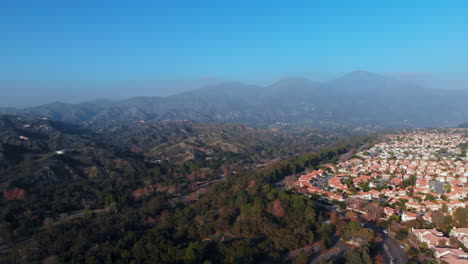Aerial-pan-over-a-suburban-city-with-mountain-background
