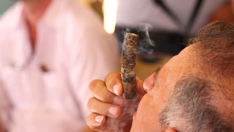 Macho-Caribeño-Mayor-Con-Manos-Temblorosas-Fumando-El-Extremo-De-Un-Cigarro-Marrón