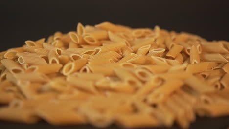 Italian-pasta-falling-on-black-surface-slow-mo-100fps
