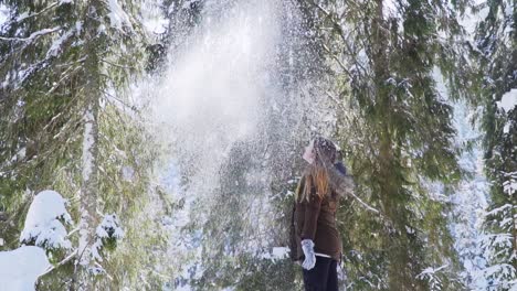 Wide-shot-of-girl-throwing-fresh-snow-in-the-air-slow-motion