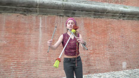 SlowMotion-Pan-of-Girl-with-Dreadlocks-Spinning-Sticks-as-part-of-Circus-Skills