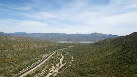 Aerial-desert-highway-leads-to-Bartlett-Lake-a-reservoir-formed-by-the-damming-of-the-Verde-River-Tonto-National-Forest,-Sonoran-Desert,-Arizona