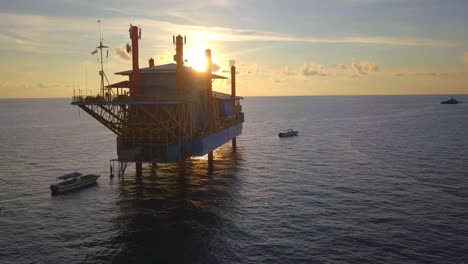 Aerial-flight-at-stunning-sunset-over-ocean-around-an-oil-rig-in-Mabul,-Malaysia